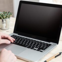 Computer laptop with black blank screen on a wooden desk