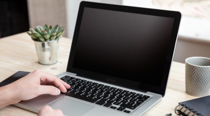 Computer laptop with black blank screen on a wooden desk